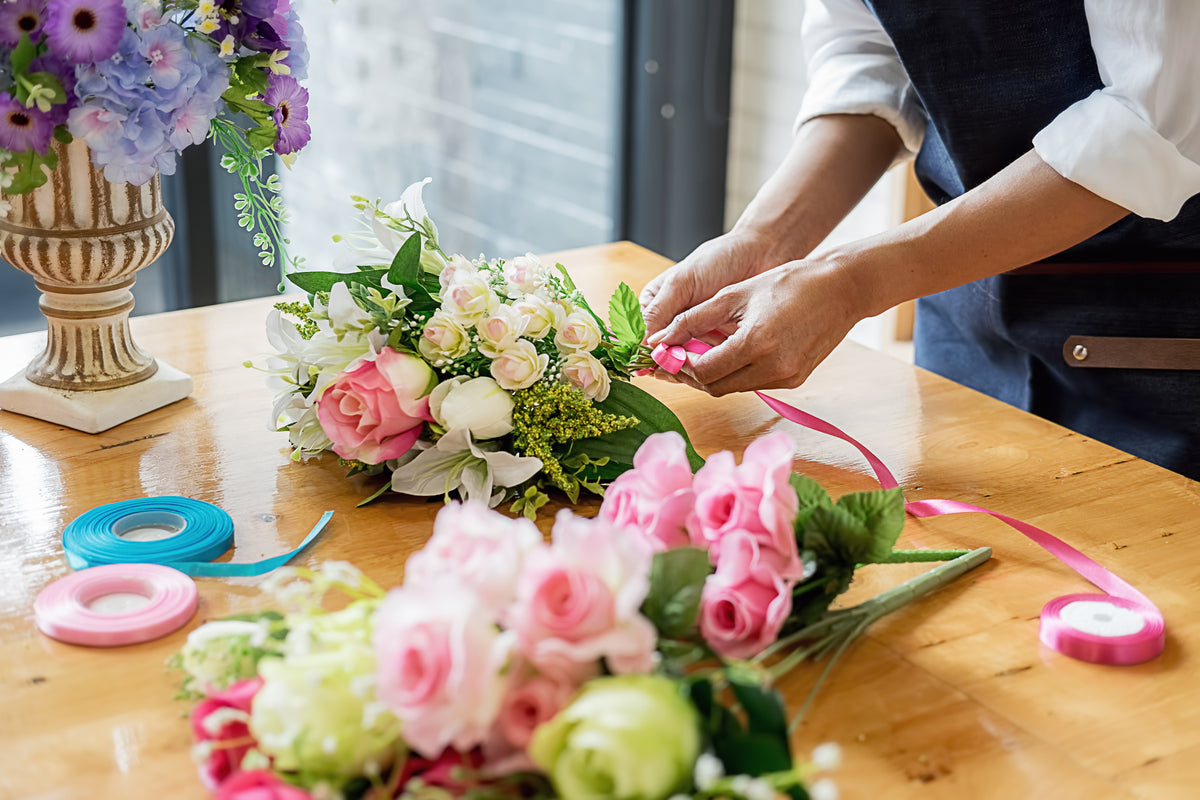 Florist arranging a bouquet of pink and cream flowers